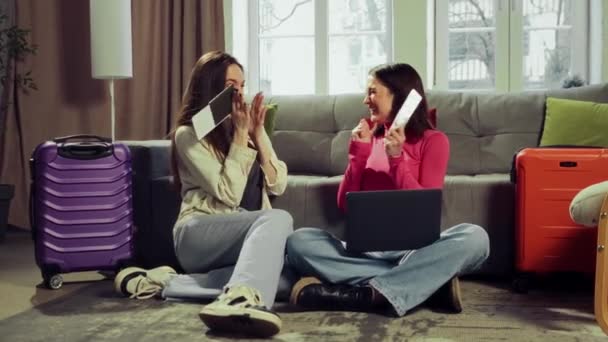 快乐的年轻姑娘们坐在家里买票 在线预订旅馆 为即将到来的旅行做准备 旅游公司 预订服务的概念 — 图库视频影像