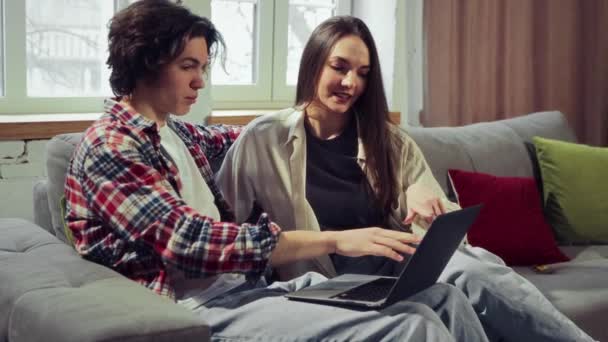 Menino Menina Sentados Sofá Casa Usando Laptop Para Reservar Bilhetes — Vídeo de Stock