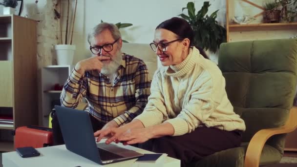 Starsza Para Siedzi Domu Wybiera Wycieczkę Wakacje Online Pomyślna Rezerwacja — Wideo stockowe