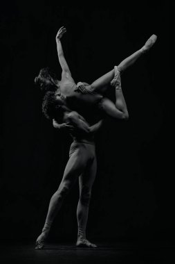 Dinamik sanatsal duruş. Genç adam ve kadın, bale dansçıları yaratıcı ve tutkulu bir performans sergiliyorlar. Siyah ve beyaz. Klasik sanat, estetik, duygular, bale, yetenek kavramı