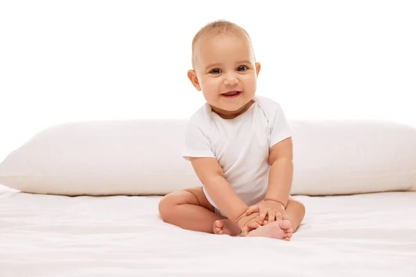 小さい赤ん坊の少女 白い子供の幸せな子供は枕でベッドに座って白い背景に微笑みました 幸せとは 幼少期 幼児期 ヒースの概念 — ストック写真