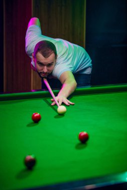 Bilardo masasına yaslanmış, bilardo oynayan konsantre genç bir adam. Lifestyle dergisi boş zamanları ön plana çıkarıyor. Bilardo, spor, kumar, hobi, eğlence, oyun kavramı