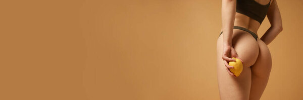 Cropped image of smooth female buttocks. Model posing in cotton underwear against beige studio background. Anti-cellulite care. Concept of body and health care, female beauty, wellness. Banner