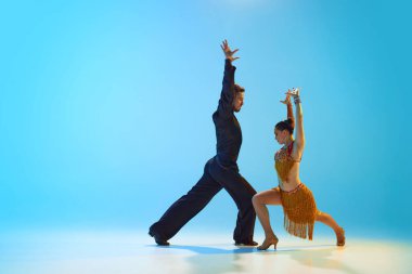 Artistik, tutkulu genç adam ve kadın hareket halinde, dans salonu, Latin dansı neon ışıkta mavi arka planda. Dans sınıfı kavramı, hobi, sanat, dans okulu, yetenek.
