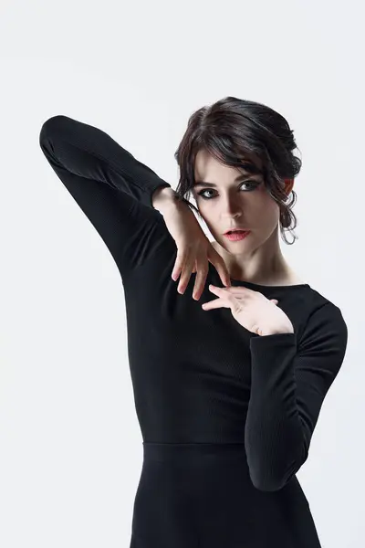 エレガントで柔らかい若い女性の肖像画 ダークメイク 情熱的なポーズ 白いスタジオの背景に黒い服でポーズ 美しさ ファッションの概念 — ストック写真