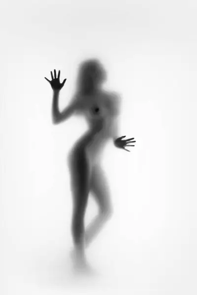 Monochrome, blurred silhouette of female figure with arms raised in motion. Black and white. tenderness and sensuality. Concept of body aesthetics, femininity, beauty, health, art
