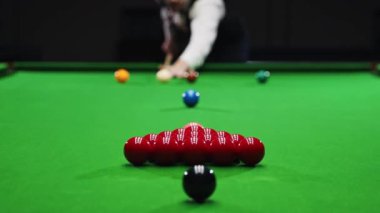 Beyaz gömlekli bulanık bir genç adam bilardo oynuyor, bilardo oynuyor, ıstakayla atış yapmaya odaklanıyor. Konsantrasyon ve hassasiyet. Toplara odaklan. Bilardo, spor, kumar, hobi, eğlence, oyun konsepti
