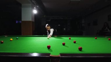 Vuruş yapan bir oyuncunun dinamik çekimi, bilardo şampiyonası ve yerel turnuvalar için enerji ve heyecan ifade ediyor. Toplara odaklan. Bilardo, spor, kumar, hobi, eğlence kavramı.