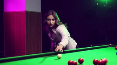Bilardo oynayan bir kadın yeşil masadaki bilardo toplarını hedef alıyor. Snooker maçı, turnuva. Sosyal kulüp üyeliği broşürü. Bilardo, spor, kumar, hobi, eğlence, oyun kavramı
