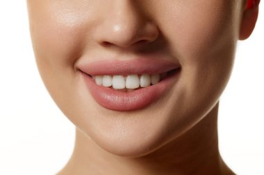 Kadınlara yakın çekim, alt yüz, pürüzsüz cilt, dolgun dudaklar ve beyaz dişler. Beyaz arka planda poz veren bir model. Doğal güzellik kavramı, kozmetik, kozmetik, cilt bakımı, diş bakımı