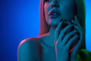 Güzel dolgun dudakların yakın plan görüntüsü mavi stüdyonun arka planında, neon ışıkta. Dudak büyütme. Doğal güzellik kavramı, kozmetik, kozmetik, cilt bakımı ve sağlık