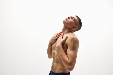 Yakışıklı, üstsüz vücut şekli, omuzlarında doğum lekesi beyaz stüdyo arka planında izole edilmiş kot pantolonla üstsüz poz veriyor. Spor yaşam tarzı kavramı, vücut ve sağlık hizmetleri, gençlik