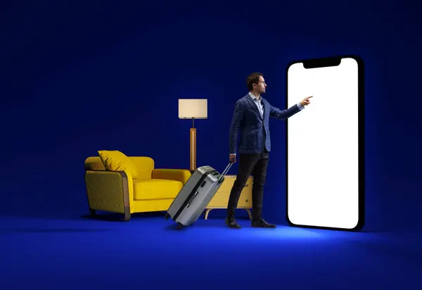 Seorang Pria Berdiri Dengan Koper Rumah Dekat Sofa Kuning Menunjuk — Stok Foto