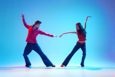 Modaya uygun genç adam ve güzel kadın mavi arka planda rock 'n roll dansı yapıyorlar. Hobi kavramı, dans sınıfı, parti, 50 'ler, 60' lar kültürü, gençlik