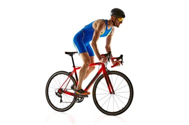 Atletik genç adam, üniformalı bisikletçi, miğfer ve gözlük takan beyaz stüdyo arka planında izole edilmiş bisiklet süren. Spor anlayışı, aktif ve sağlıklı yaşam tarzı, hız, dayanıklılık, hobi