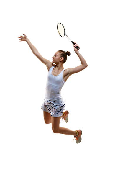 Full-length image of motivated athlete in motion, young girl, badminton player hitting shuttlecock in jump isolated over white background. Concept of professional sport, active lifestyle, hobby, game