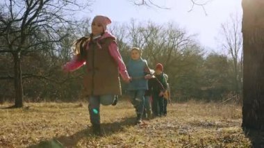 Oyuncu aktif çocuklar. Oğlanlar ve kızlar, arkadaşlar sıcak bir sonbahar gününde ormanda vakit geçirir, koşar, oynarlar. Boş zaman aktivitesi, çocukluk, arkadaşlık, aktif yaşam tarzı, eğlence konsepti