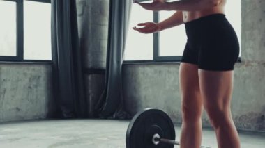 Spor vücutlu iki fit kadın spor salonunda halterin yanında birbirlerine beşlik çakıyor. Ortaklık ve destek. Profesyonel spor anlayışı, aktif yaşam tarzı, vücut geliştirme. Ad