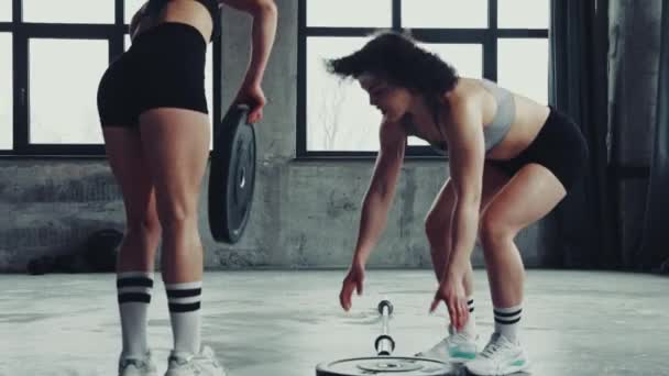 Две Юные Спортсменки Бодибилдер Спортивной Одежде Готовятся Поднять Тяжелую Штангу — стоковое видео