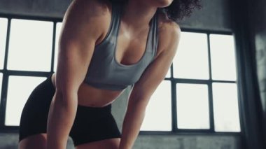 Atletik vücutlu genç kadınlar sıkı eğitimden sonra yorgun hissediyorlar, derin nefes alıyorlar ve antrenmanlar arasında dinleniyorlar. Profesyonel spor anlayışı, aktif yaşam tarzı, vücut geliştirme, motivasyon, aksiyon. Ad