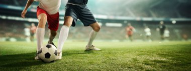Erkek bacaklarının dinamik görüntüsü, futbol oyuncuları top sürerken hareket halindeler, arka planda bulanıklık olan 3D stadyum modelinde futbol oynuyorlar. Profesyonel spor kavramı, rekabet, turnuva