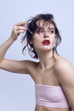 Kozmetik enjeksiyonlar ve değişiklikler. Yanaklarında şırınga ve yüzünde çizikler olan güzel genç bir kadın. Modern güzellik standartları kavramı, plastik cerrahi, sağlık, kozmetoloji