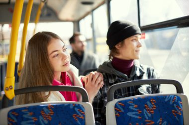 Arkadaşlar, genç adam ve kadın bulanık yolcu ve şehir geçmişiyle modern tramvayda oturuyorlar. Ulaşım. İyi yolculuklar. Toplu taşıma kavramı, kentsel yaşam tarzı