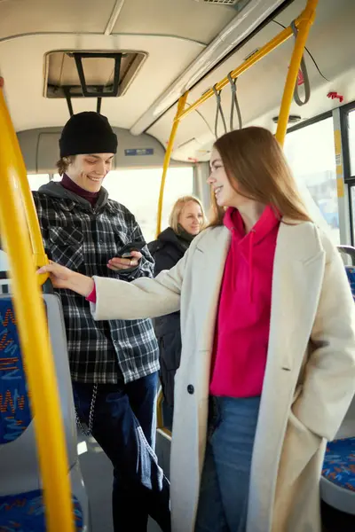 Young people standing in public transport, tram, bus. Easy of access to urban transport. Convenient city movements. Concept of public transport, urban lifestyle