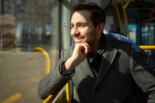 公共交通機関を使用して灰色のパットで笑顔の男のクローズアップ画像 トラムに座って 笑顔で窓を見ています 晴れた日 公共交通機関 都市生活のコンセプト — ストック写真