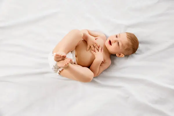 Petit Garçon Couche Enfant Couché Sur Dos Tenant Les Pieds — Photo