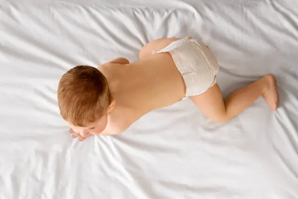Όμορφο Αγοράκι Πάνα Ξαπλωμένο Στο Κρεβάτι Σέρνεται Παίζει Απομονωμένο Λευκό — Φωτογραφία Αρχείου