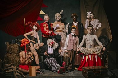 Eskimiş sirk sanatçılarının çeşitli oyuncuları sahne arkasında karanlık retro sirk pozları veriyor. Gelecek gösteriler için promosyon posteri. Sirk, tiyatro, performans, gösteri, retro ve