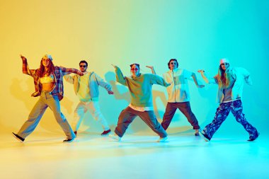 Genç insanlar, dinamik pozlarda dans eden erkekler ve kadınlar hip hop, neon ışıkta yeşil arka plandaki gradyan ile çağdaş dans ediyorlar. Modern dans stili kavramı, aktif yaşam tarzı, gençlik kültürü