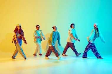 Genç insanlar, dinamik pozlarda dans eden erkekler ve kadınlar hip hop, neon ışıkta yeşil arka plandaki gradyan ile çağdaş dans ediyorlar. Modern dans stili kavramı, aktif yaşam tarzı, gençlik kültürü