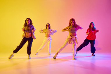 Spor tarzında şık genç kadınlar gündelik kıyafet günah hareketi, dans eden hip hop, neon ışıkta değişen arka plana kafa yormak. Gençlik kavramı, sokak dansı, modern dans, modern dinamik.