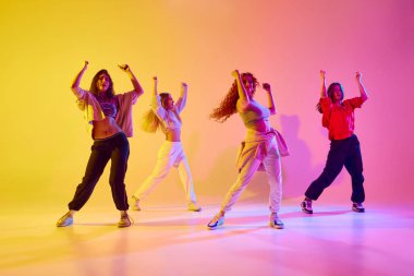 Genç insanların dinamik görüntüsü, hareketli kadın dansçılar neon ışıkta modern tarz dansları yapıyorlar. Gençlik kavramı, sokak dansı, modern dans, modern dinamik.