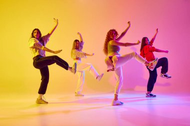 Genç insanların dinamik görüntüsü, hareketli kadın dansçılar neon ışıkta modern tarz dansları yapıyorlar. Gençlik kavramı, sokak dansı, modern dans, modern dinamik.