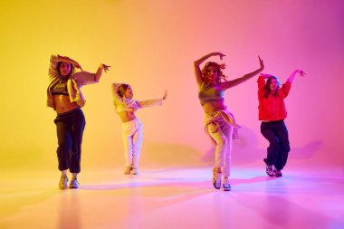 Genç insanların dinamik görüntüsü, hareketli kadın dansçılar neon ışıkta modern tarz dansları yapıyorlar. Gençlik kavramı, sokak dansı, modern dans, modern dinamik.