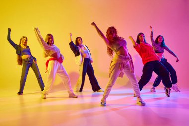 Genç, yetenekli, güzel kadınlar hip hop yapıyor, düşüncelere dalıyor, neon ışıkta arka plandaki değişime karşı serbest stil yapıyor. Gençlik kavramı, sokak dansı, modern dans, modern dinamik.