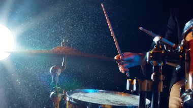 Siyah arka planda el fenerleriyle davul seti yakın plan. Davul çalan erkek müzisyen. Canlı performans. Müzik kavramı, enstrümanlar, konser, ses, ekipman, festival