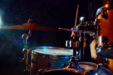 Siyah arka planda el fenerleriyle davul seti yakın plan. Davul çalan erkek müzisyen. Canlı performans. Müzik kavramı, enstrümanlar, konser, ses, ekipman, festival