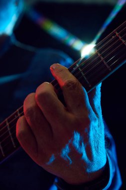 Arka planda gitar çalan erkek ellerinin yakın çekimi. Akustik performans. Müzik kavramı, enstrümanlar, konser, ses, ekipman, festival