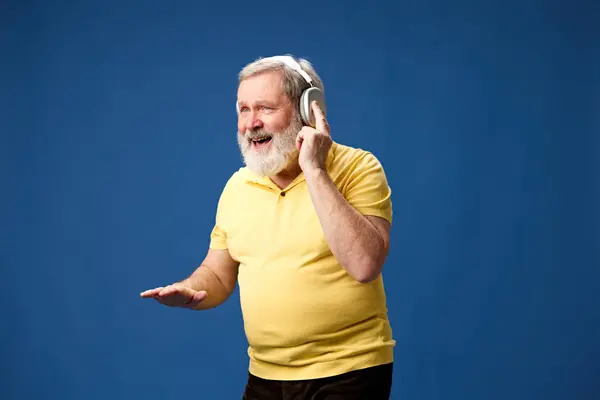 Anciano Barbudo Polo Amarillo Escuchando Música Auriculares Sobre Fondo Azul —  Fotos de Stock