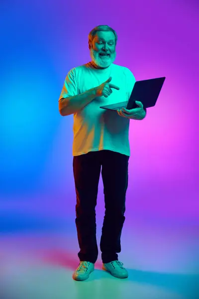 Dizüstü Bilgisayarıyla Ayakta Duran Gülümseyen Ekranda Mavi Mor Arkaplanda Neon — Stok fotoğraf