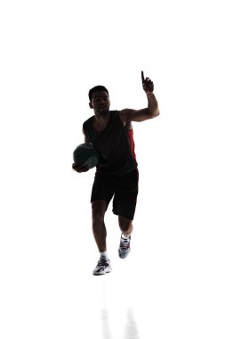 Young sportive man, basketball player in uniform with ball training during game isolated on white background. Silhouette. Concept of professional sport, competition, game, tournament, action clipart