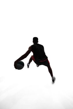 Basketbolcunun silueti topla hareket ediyor, beyaz arka planda tek başına oynayan bir sporcu yapıyor. Profesyonel spor, rekabet, oyun, turnuva, aksiyon kavramı