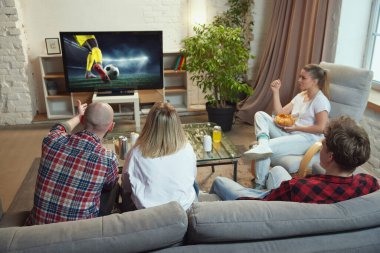 Arkadaşlar, spor hayranları evde buluşuyor, gündüz vakti oturma odasında kanepede oturuyor ve çevrimiçi futbol maçı çevirisini izliyorlar. Spor, şampiyonluk, eğlence ve eğlence anlayışı