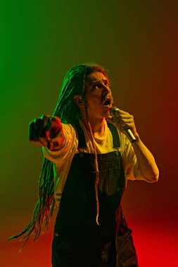 Rastalı bir adam tarafından yaratılan duygusal atmosfer neon ışıkta değişen yeşil arka plana karşı unutulmaz bir ses performansı sergiliyor. Müzik, performans, festival, konser kavramı