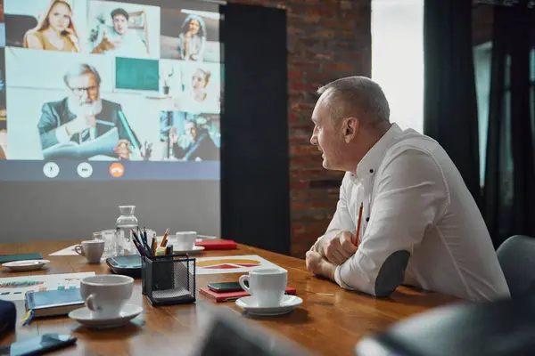 Empresário Sentado Sala Conferências Tendo Videochamada Line Tela Com Funcionários — Fotografia de Stock