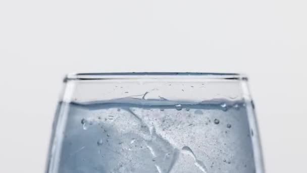 Kostka Lodu Wpada Szklanki Wypełnionej Czystą Wodą Odizolowaną Białym Tle — Wideo stockowe